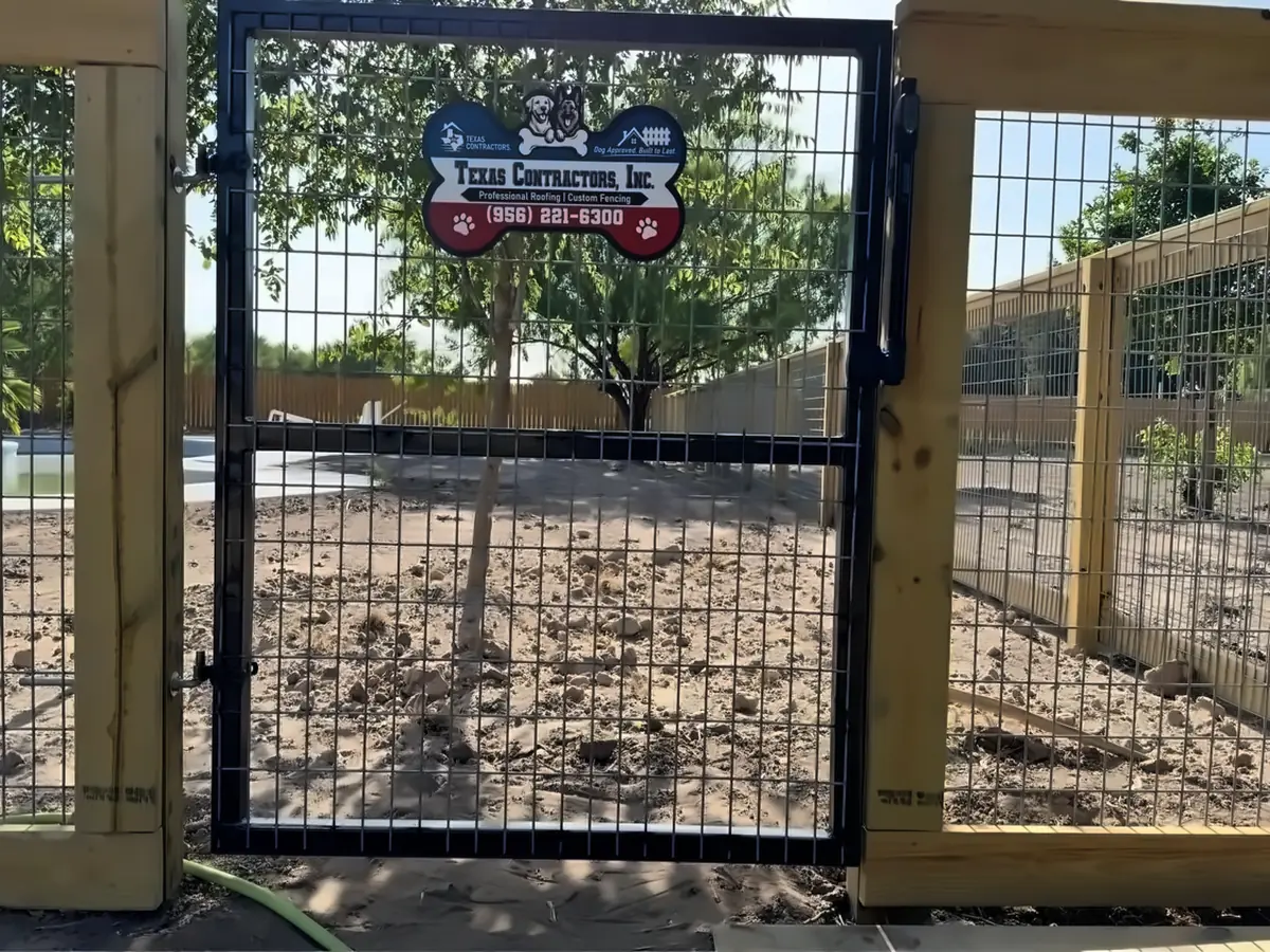 Portón reforzado de metal negro con alambre de panel para caballos en una cerca a la medida construida para un centro de entrenamiento de perros en McAllen, Texas
