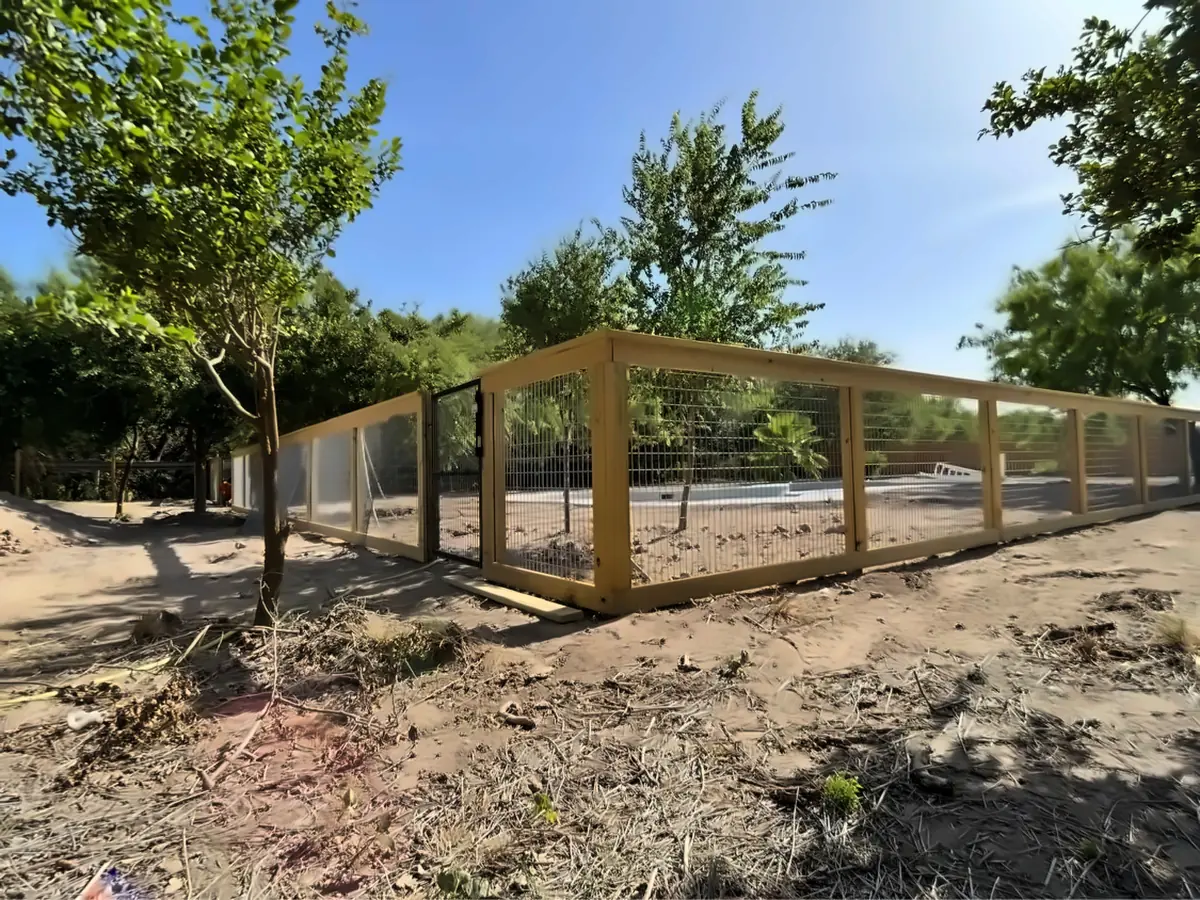 Cerca a la medida con alambre de panel para caballos calibre 6, postes de madera y un portón reforzado, construida para un centro de entrenamiento de perros en McAllen, Texas