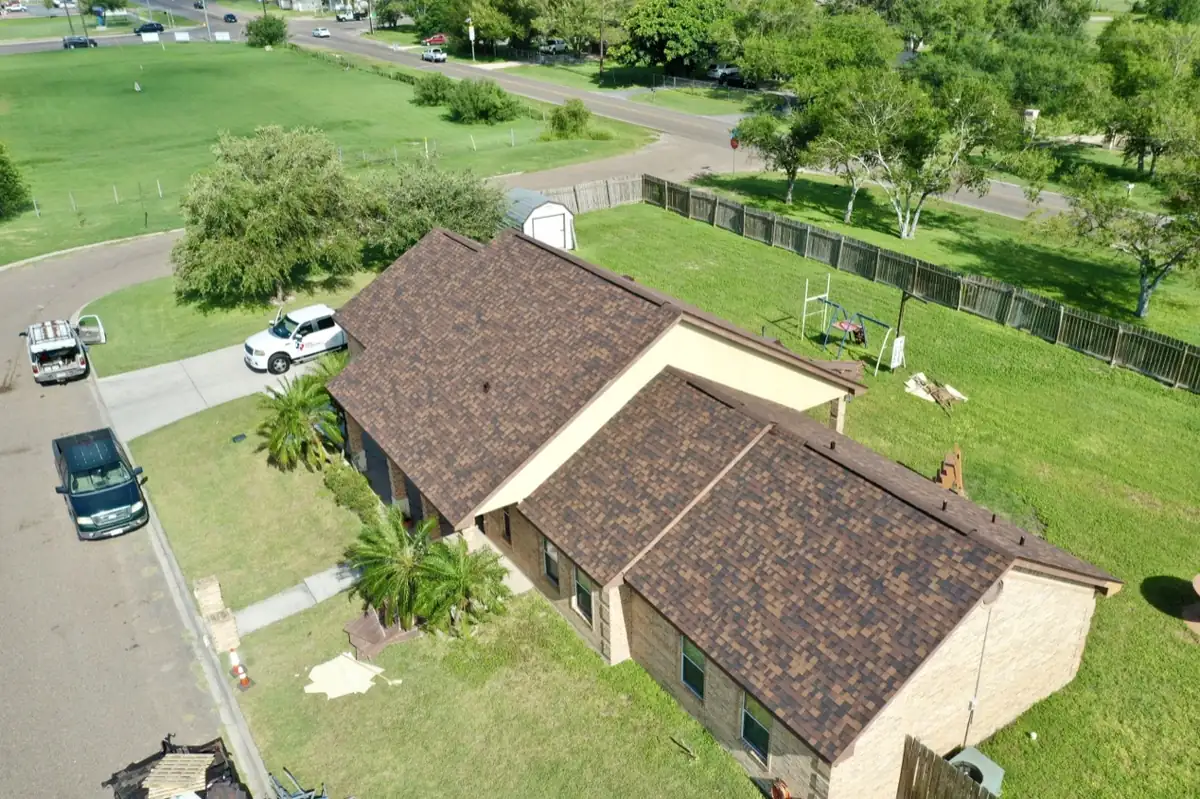 Vista de dron de un techo terminado de tejas de asfalto arquitectónicas color café en una casa de ladrillo del Valle del Río Grande